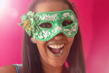 people, holidays, emotion and carnival concept - happy young woman with mask and confetti at carnaval party. Carnaval concept