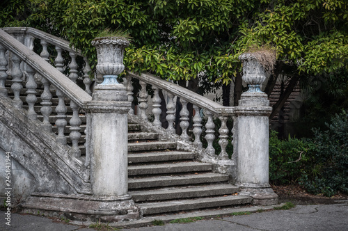 Fotografía Ancient staircase with stone balusters against the background of green vegetation