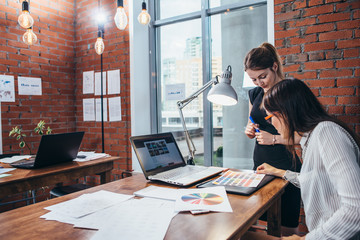 Wall Mural - close-up view of interior designer workspace with laptop, graphic tablet, phone and color palette on