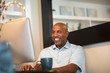 © digitalskillet1 - Mature African American man working from his home office.