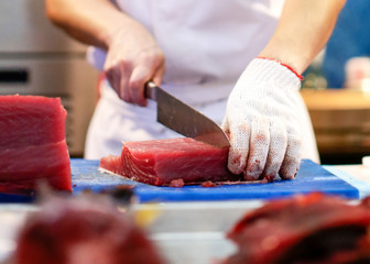 Wall Mural - Chef cutting fresh tuna fish in the kitchen