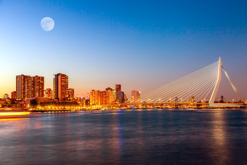 Erasmus bridge over the river Meuse with skyscrapers and moon in Rotterdam, South Holland, Netherlands during twilight sunset. Rotterdam panorama