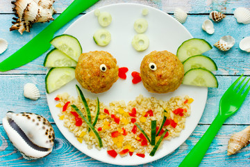 Wall Mural - Food art idea healthy lunch for kids chicken meatballs with bulgur porridge and fresh vegetables shaped cute fishes