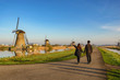 © Noppasinw - Rotterdam Netherlands, Love couple walking with Dutch Windmill at Kinderdijk Village