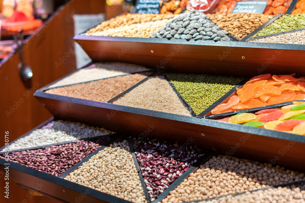 counter with rows of different grains in the market store f - obrazy, fototapety, plakaty 