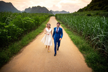 Happy couple having fun in the field at sunset