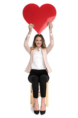 Sticker - happy businesswoman holds red heart shape in the air