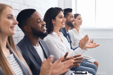 Group of businesspeople clapping hands at meeting