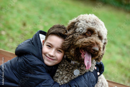Junge kuschelt mit seinem Hund StockFoto Adobe Stock
