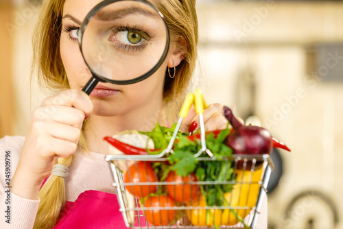 Fotomural Woman investigating shopping backet with vegetables