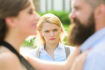 Wall Mural - Going into a jealous rage. Jealous woman look at couple in love on street. Unhappy girl feeling jealous. Bearded man cheating his girl with another woman. Romantic couple of man and woman dating