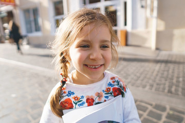 Sticker - smiling girl holding book in street