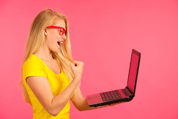 Beautiful young woman holds a laptop gesture surprise and success isoalted