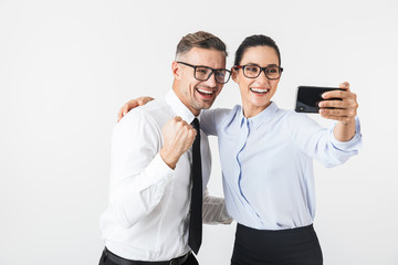 Wall Mural - Young business colleagues couple isolated over white wall background take selfie by mobile phones.