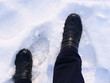 © whiteaster - Person's feet in leather boots walking in the snow in winter