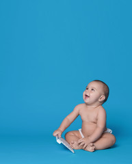 Baby with keyboard of modern computer looking up