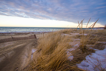 Winter Beach Sunset. Sunset along the freshwater coast of Lake Huron with dune grass in the foreground.