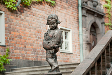 Sculpture of boy with catching fish in courtyard of Stockholm Stadshuset, built in 1923. Examples of national romanticism in architecture of Sweden