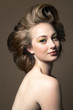 © Andreas Kuehn - Portrait of a young woman with make up wearing her hair in a big hair style, profile.