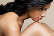 © Andreas Kuehn - Naked, young, black woman resting her chin on her knee, profile.