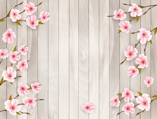 Poster - Cherry branch with a pink flowers on wooden background. Vector