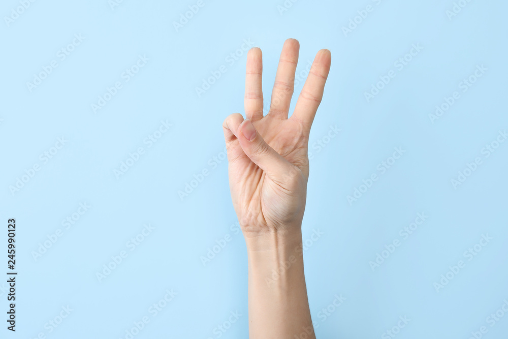 Woman showing W letter on color background, closeup. Sign language - obrazy, fototapety, plakaty 