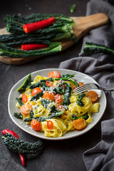 Poster - Tagliatelle pasta with kale, tomatoes, pepper and parmesan cheese. Vertical image.