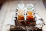Spices and seasonings in glass jars on wooden container