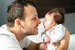 © Louis-Photo - Father and newborn baby closeup on the bed.