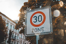 30 Speed Sign In A City Street With Sun Flare