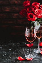 Two Wine Glasses Of Rose Wine On Brick Background, Bouquet Of Red Roses For Romantic Evening For Valentines Day Surprise, Marriage Proposal Passion And Love Celebration, Copy Space 