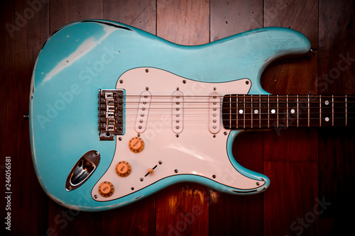 Fotografía Light blue electric guitar in a brown wood background