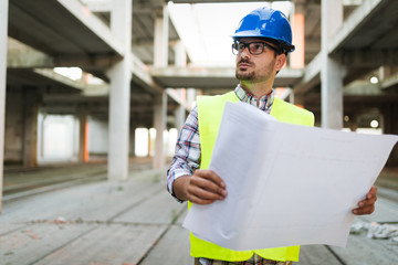 Picture of construction site engineer looking at plan