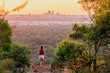 Girl watches sunset over the Perth City skyline from the Perth hills (Kalamunda Zig Zag). Perth, Western Australia, Australia.