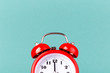 Half part of red alarm clock on blue background with copy space.