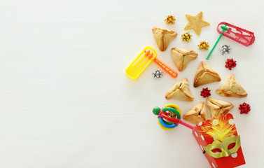 purim celebration concept (jewish carnival holiday) over white wooden background. top view, flat lay