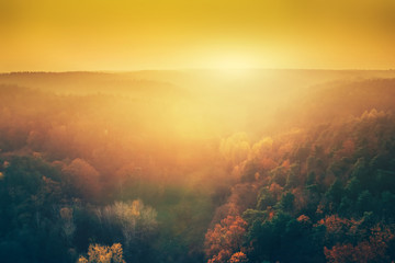  Sun setting above forest in aerial view.