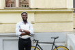 © F8  \ Suport Ukraine - Young african man walking on stairs with laptop, go to the bicycle