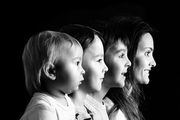 Poster - Family portrait of mother and three boys, profile picture of them all in a row, isolated on black background