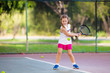 © famveldman - Child playing tennis on outdoor court