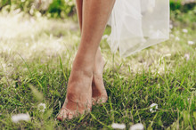 Bride Barefoot Bride Stands On Green Grass Where Daisies Grow