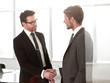 © ASDF - handshake business partners on the background of the workplace