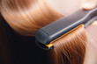© Parilov - Hair iron in hand of master straightens with keratin