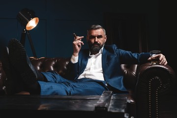 Wall Mural - Attractive man with cigar and a glass whiskey