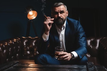 Attractive man with cigar and a glass whiskey