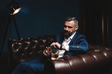 Wall Mural - Attractive man with cigar and a glass whiskey