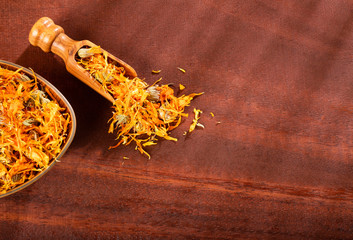 Wall Mural - Dried calendula petals - Calendula officinalis. Wood background