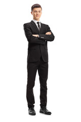 Wall Mural - Young male adult in an elegant suit posing with his hands crossed