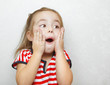 © Ilshat - Surprised little girl with open mouth and hands on cheeks