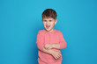 © New Africa - Little boy scratching arm on color background. Annoying itch